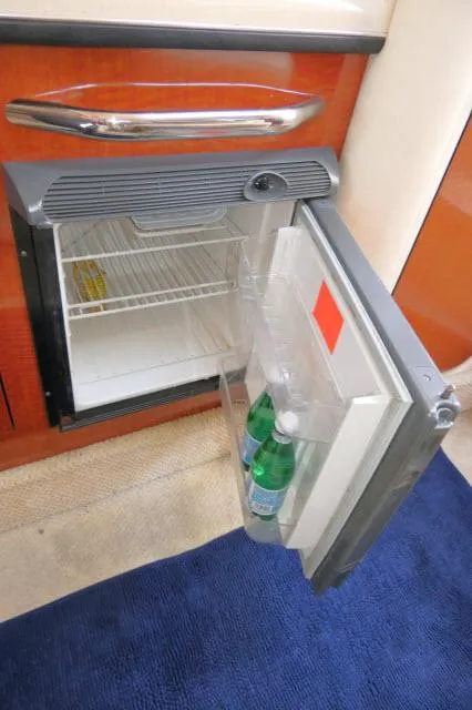 Slide: The Image of Mini fridge inside 2005 Sea Ray 280 Sundancer yacht, open with bottles inside. - 17