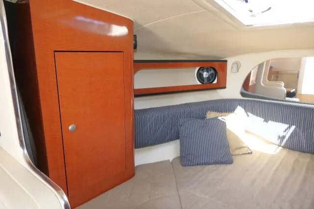 Slide: The Image of 2005 Sea Ray 280 Sundancer cabin interior with wood cabinetry and striped cushions. - 18
