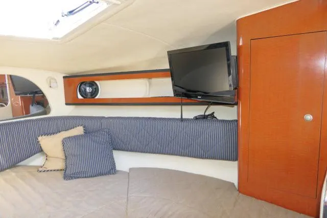 Slide: The Image of Interior of 2005 Sea Ray 280 Sundancer with TV, striped cushions, and wooden cabinetry. - 19