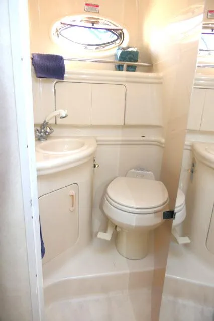Slide: The Image of 2005 Sea Ray 280 Sundancer bathroom with sink, toilet, and porthole window. - 27
