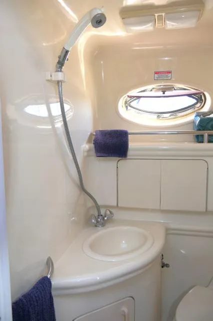 Slide: The Image of 2005 Sea Ray 280 Sundancer bathroom with shower, sink, and porthole window. - 28