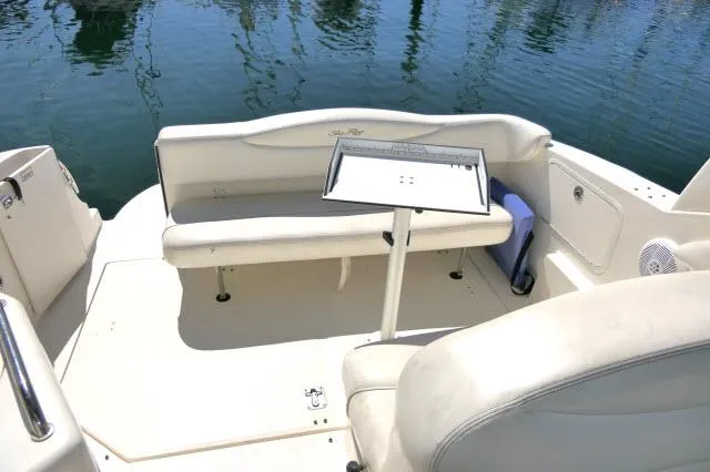 Slide: The Image of 2005 Sea Ray 280 Sundancer boat interior with seating and table on calm water. - 29