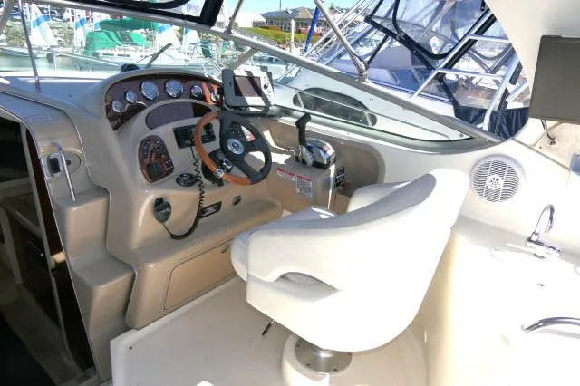 Slide: The Image of 2005 Sea Ray 280 Sundancer cockpit with steering wheel, gauges, and captain's chair. - 36