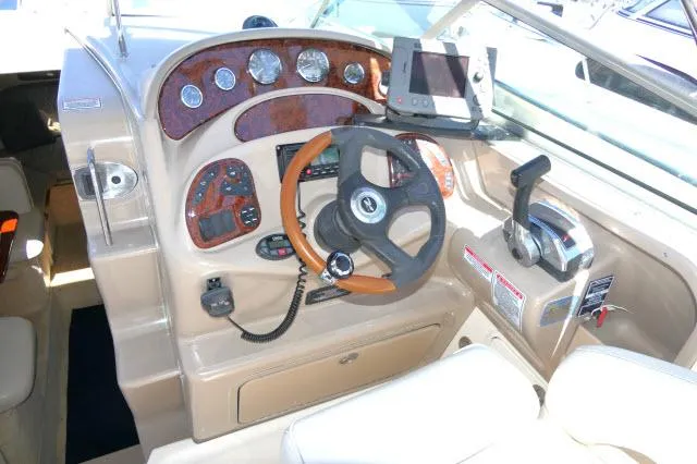 Slide: The Image of 2005 Sea Ray 280 Sundancer helm with steering wheel, gauges, and navigation equipment. - 38