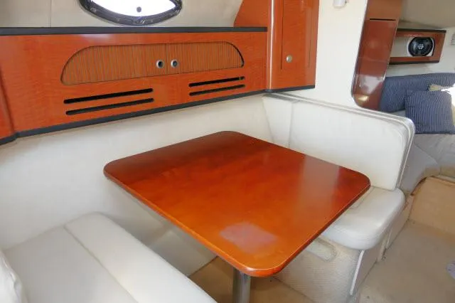 Slide: The Image of 2005 Sea Ray 280 Sundancer cabin with wooden table and white seating. - 4