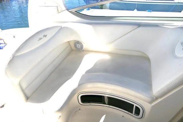 Slide: The Image of 2005 Sea Ray 280 Sundancer interior seating with white upholstery and built-in speaker. - 40