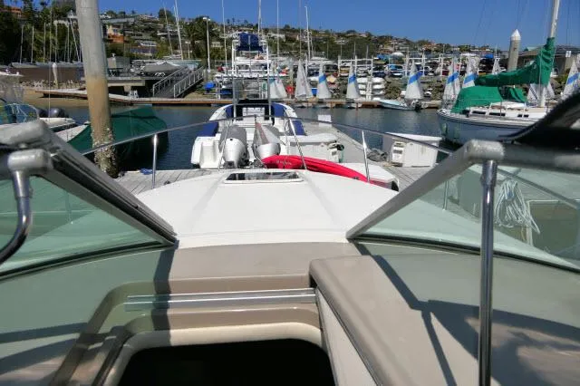 Slide: The Image of 2005 Sea Ray 280 Sundancer docked at a marina with sailboats in the background. - 48