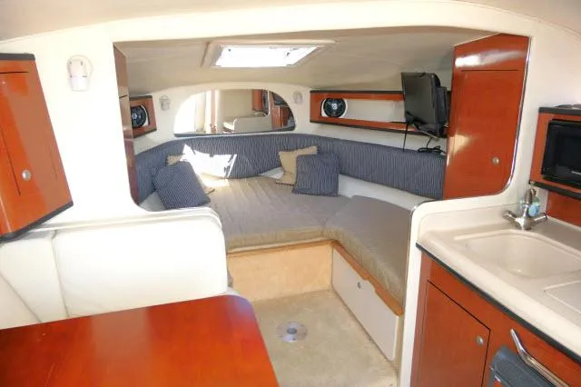 Slide: The Image of 2005 Sea Ray 280 Sundancer cabin interior with cozy seating, kitchenette, and modern amenities. - 5