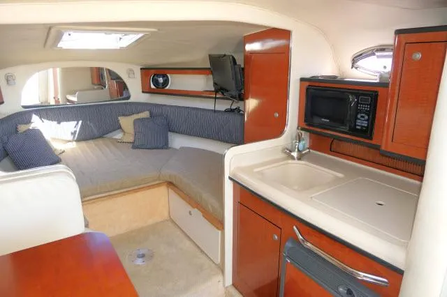 Slide: The Image of 2005 Sea Ray 280 Sundancer cabin with kitchenette, bed, and TV. - 6