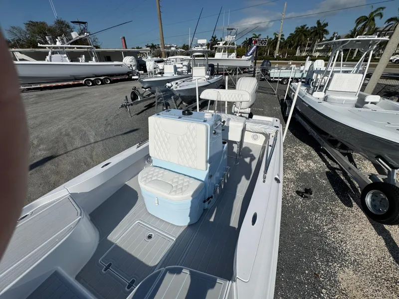Slide: The Image of 2025 Contender 23 Bay boat with seating and console, displayed in a marina setting. - 12