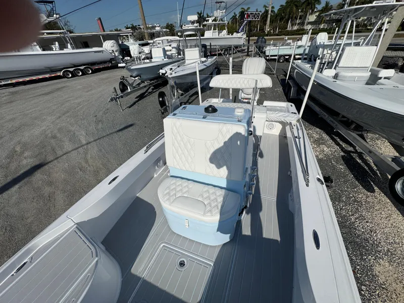 Slide: The Image of 2025 Contender 23 Bay boat with white seating and sleek design in a marina setting. - 13