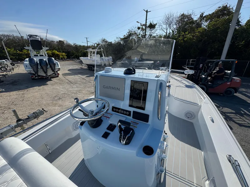 Slide: The Image of 2025 Contender 23 Bay boat with Garmin navigation system, parked outdoors. - 14