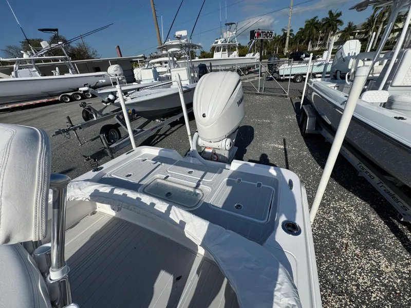 Slide: The Image of 2025 Contender 23 Bay boat with outboard motor in a marina setting. - 18