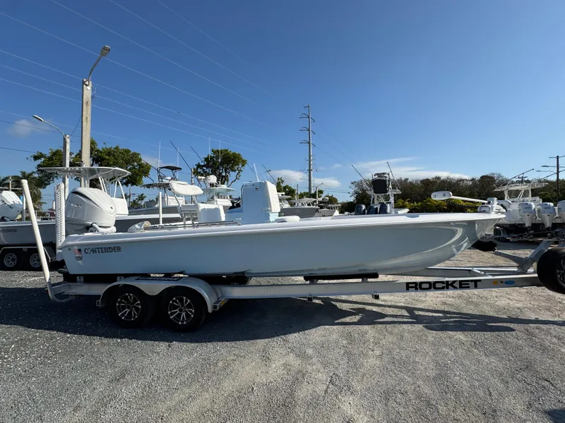 Slide: The Image of 2025 Contender 23 Bay boat on a trailer in a marina setting. - 3