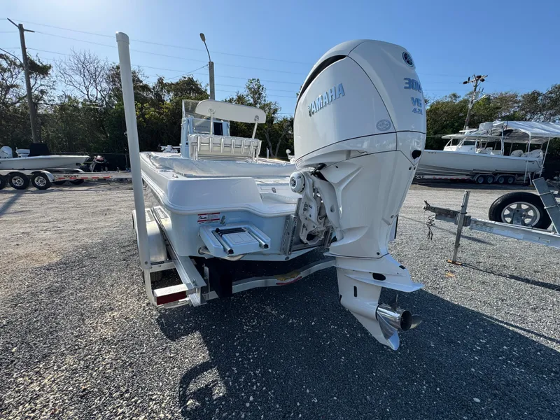 Slide: The Image of 2025 Contender 23 Bay boat with Yamaha outboard engine, parked on gravel lot. - 4