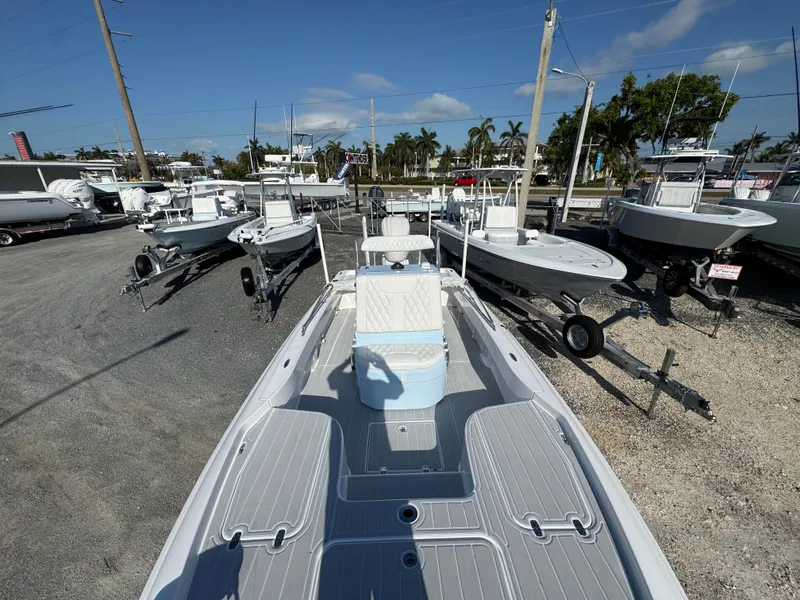 Slide: The Image of 2025 Contender 23 Bay boat on display at a dealership, surrounded by other boats. - 8