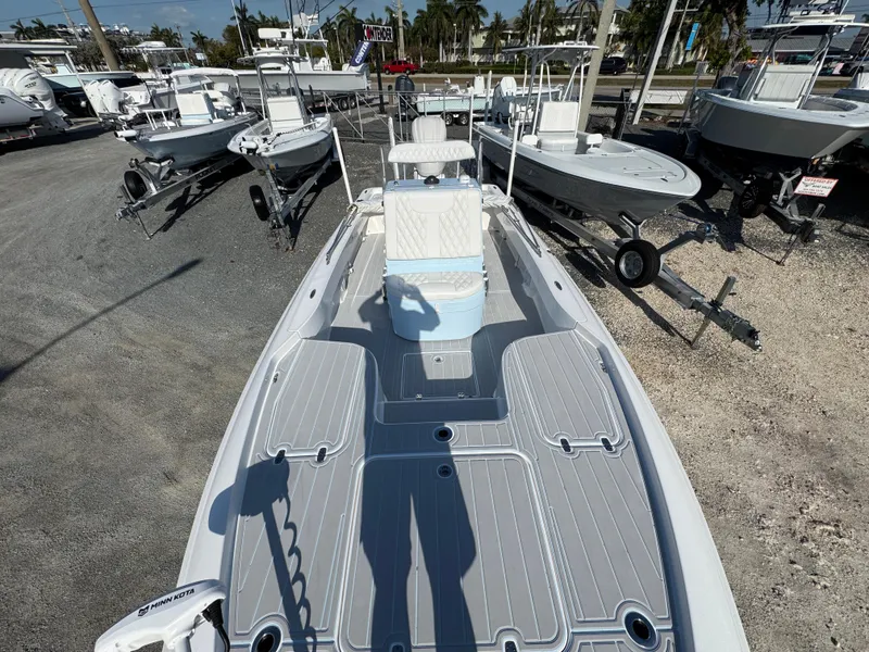 Slide: The Image of 2025 Contender 23 Bay boat on display at a marina, surrounded by other boats. - 9