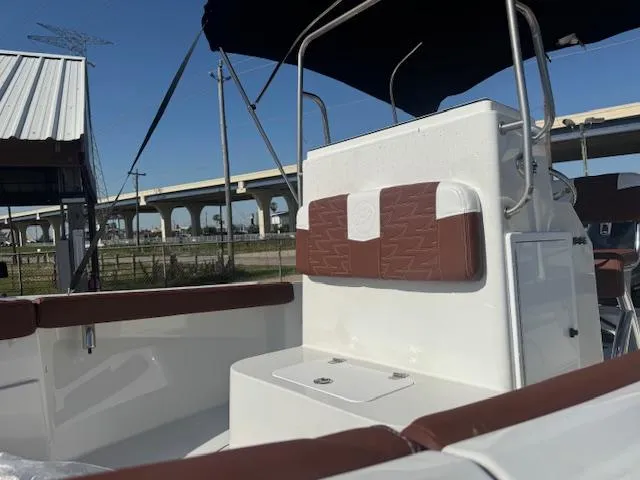 Slide: The Image of 2025 Parker 18SE Center Console boat with brown seating, under a clear blue sky. - 10