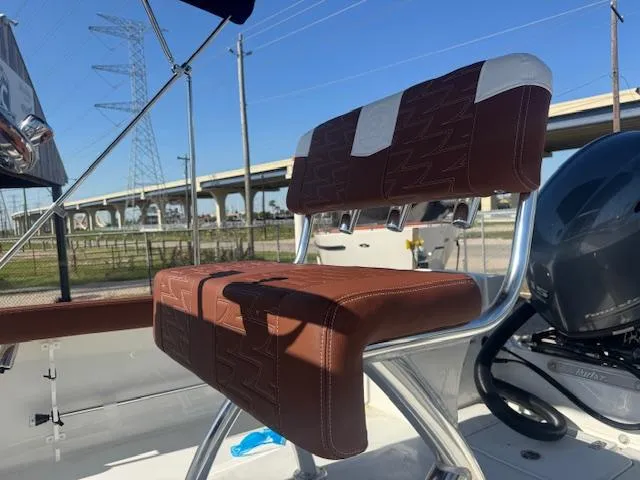 Slide: The Image of 2025 Parker 18SE Center Console boat seat with brown upholstery, under a clear blue sky. - 9