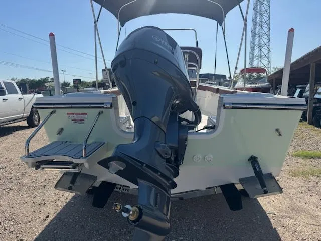 Slide: The Image of 2025 Parker 18SE Center Console boat with outboard motor, parked outdoors. - 3