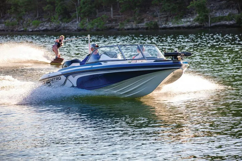 Slide: The Image of 2020 Nitro Z19 Sport boat towing a wakeboarder on a scenic lake. - 23