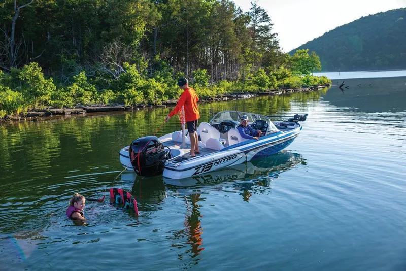 Slide: The Image of 2020 Nitro Z19 Sport boat on a lake with people swimming nearby. - 24