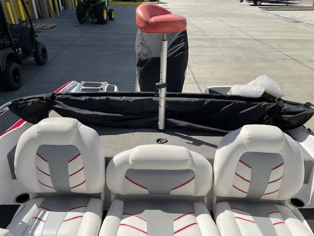 Slide: The Image of 2020 Nitro Z19 Sport boat interior with white and red seating, docked outdoors. - 6