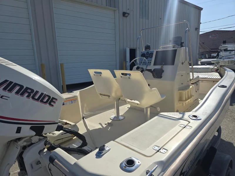 Slide: The Image of 1993 Scout 172 Sportfish boat with Evinrude motor, docked near a warehouse. - 11