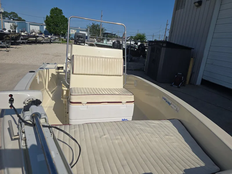 Slide: The Image of 1993 Scout 172 Sportfish boat interior with seating and storage, parked outdoors. - 12
