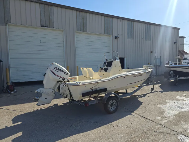 Slide: The Image of 1993 Scout 172 Sportfish boat with Evinrude motor on trailer, parked outside warehouse. - 4