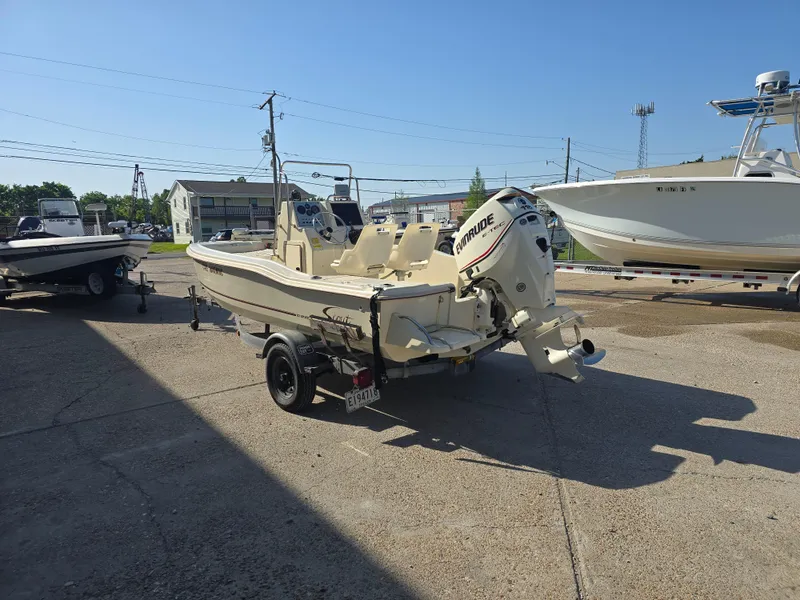 Slide: The Image of 1993 Scout 172 Sportfish boat on trailer, parked outdoors under clear blue sky. - 6