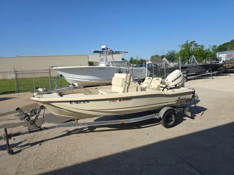 Slide: The Image of 1993 Scout 172 Sportfish boat on trailer, parked outdoors under clear blue sky. - 8