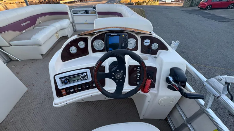 Slide: The Image of 2005 AquaPatio Cruise boat dashboard with steering wheel and control panel. - 4
