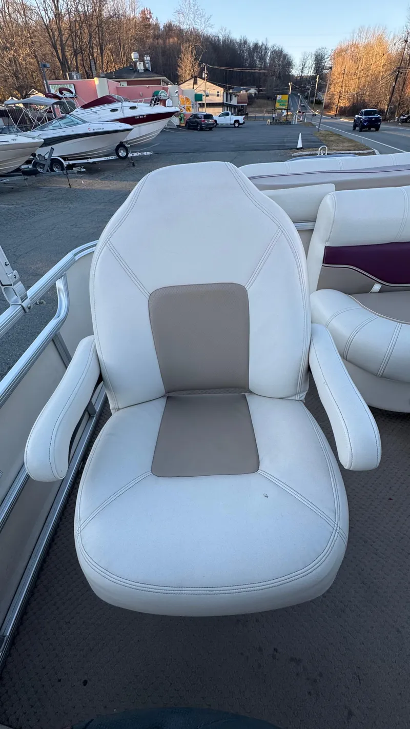 Slide: The Image of 2005 AquaPatio Cruise boat seat with white and beige upholstery, docked near a marina. - 5