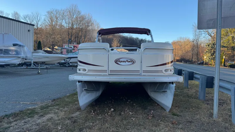Slide: The Image of 2005 AquaPatio Cruise pontoon boat parked on grass near a road and storage area. - 7