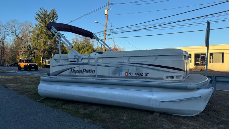 Slide: The Image of 2005 AquaPatio Cruise pontoon boat parked on grass near a road. - 8