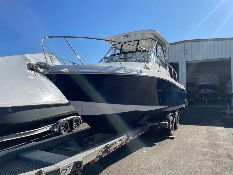 Slide: The Image of 2009 Robalo R305 Walkaround boat on trailer outside storage facility. - 1