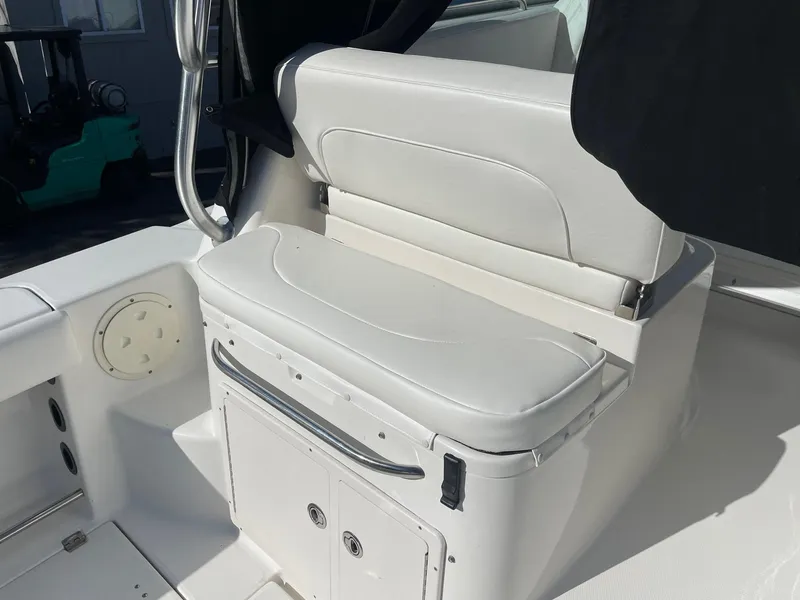 Slide: The Image of 2009 Robalo R305 Walkaround boat interior with white cushioned seating and storage. - 15