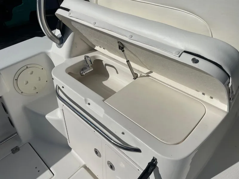 Slide: The Image of 2009 Robalo R305 Walkaround boat interior with open storage compartment and faucet. - 16