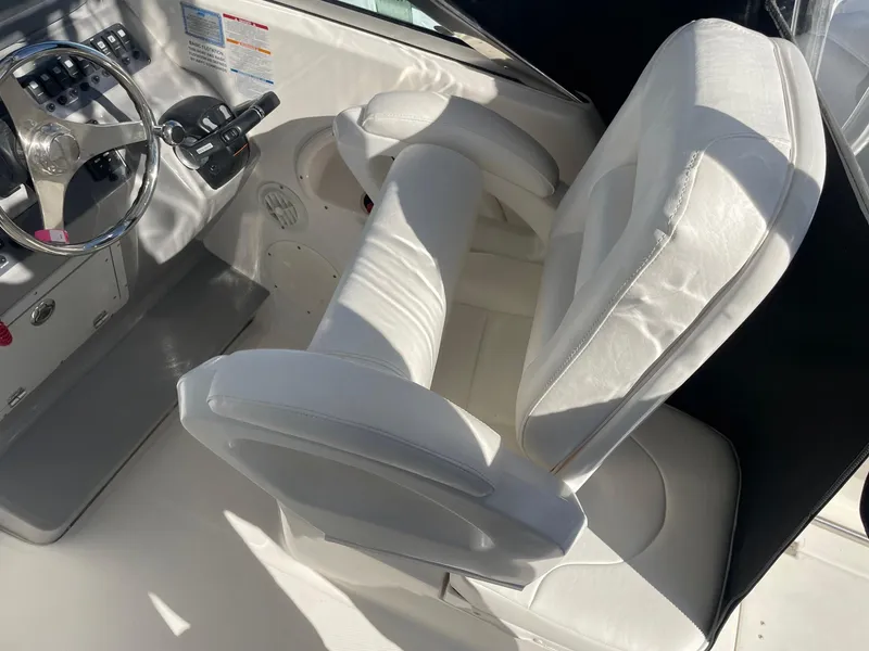 Slide: The Image of 2009 Robalo R305 Walkaround helm with white cushioned seating and steering controls. - 17