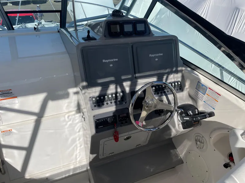 Slide: The Image of 2009 Robalo R305 Walkaround helm with dual Raymarine displays and steering wheel. - 18