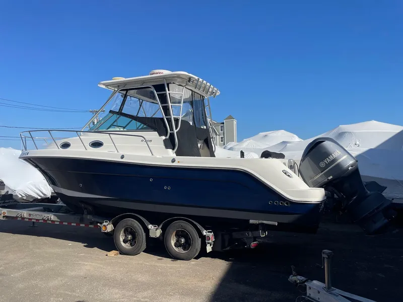 Slide: The Image of 2009 Robalo R305 Walkaround boat on trailer, featuring Yamaha outboard motor. - 2