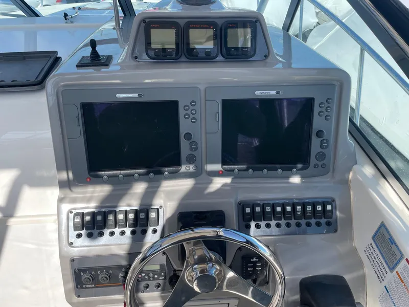 Slide: The Image of 2009 Robalo R305 Walkaround boat dashboard with dual screens and control switches. - 21