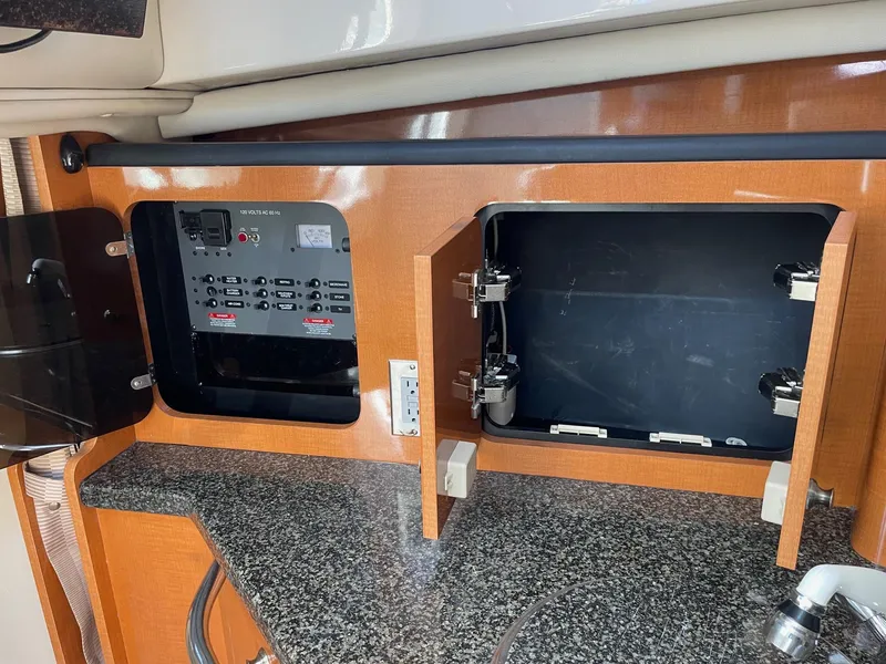 Slide: The Image of 2009 Robalo R305 Walkaround interior with open storage and control panel. - 33