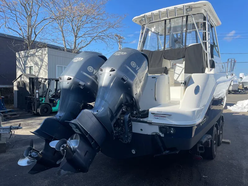 Slide: The Image of 2009 Robalo R305 Walkaround boat with dual outboard engines, parked outdoors. - 4