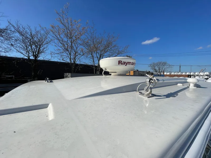 Slide: The Image of 2009 Robalo R305 Walkaround boat roof with Raymarine radar under clear blue sky. - 47