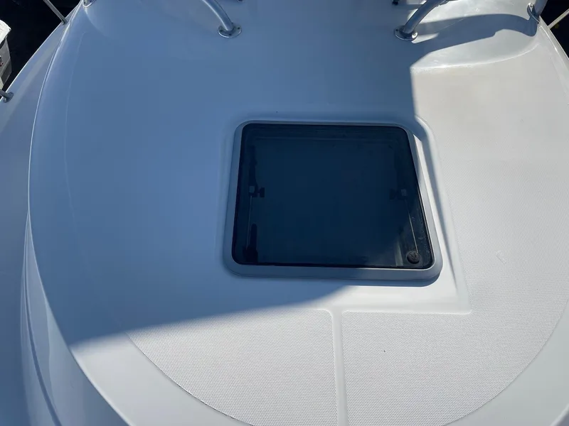 Slide: The Image of 2009 Robalo R305 Walkaround boat deck with hatch, featuring sleek design and sturdy railings. - 48