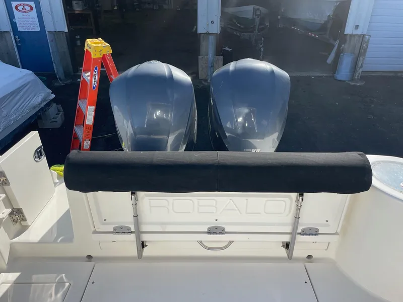 Slide: The Image of 2009 Robalo R305 Walkaround boat with dual engines and a black cushioned seat. - 7