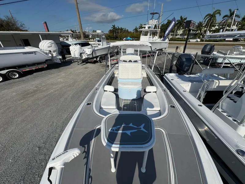 Slide: The Image of 2024 Contender 26 Bay boat with shark design table, parked in a marina. - 14