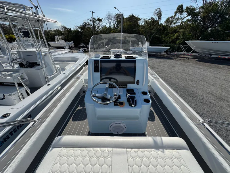 Slide: The Image of 2024 Contender 26 Bay boat cockpit with steering wheel and navigation display. - 21